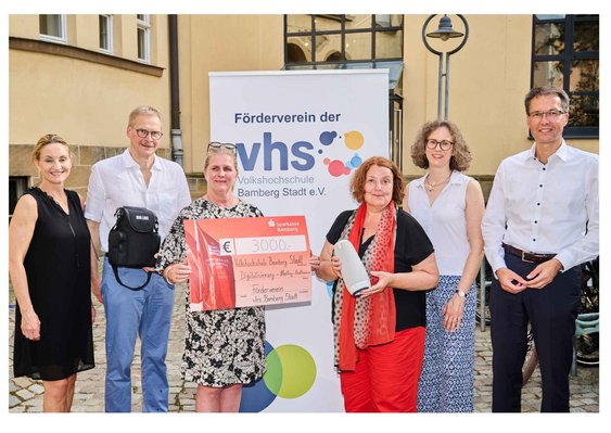 Foto: Stadtarchiv Bamberg, Jürgen Schraudner Fünf Personen aus dem Vorstand des VHS-Fördervereins übergeben einen Spendenscheck und eine Meeting-Owl für Hybridkurse an VHS-Leiterin Dr. Anna Scherbaum