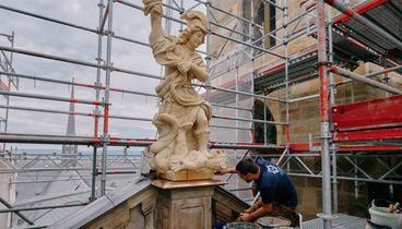 Ein Arbeiter restauriert eine Steinfigur