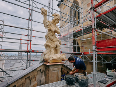 Ein Arbeiter restauriert eine Steinfigur