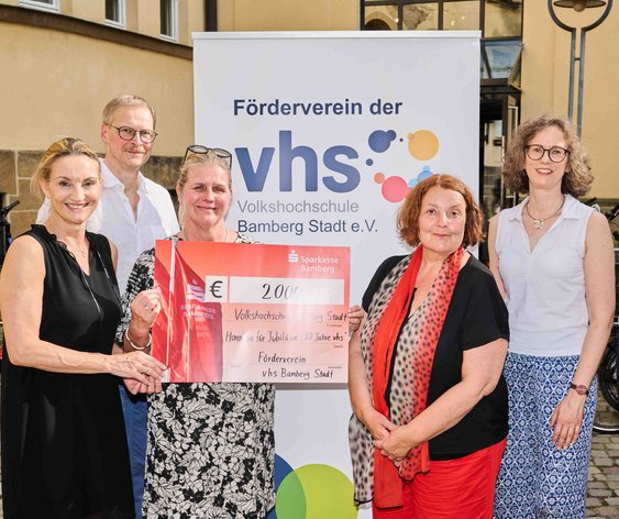 5 Personen halten einen Spendenscheck