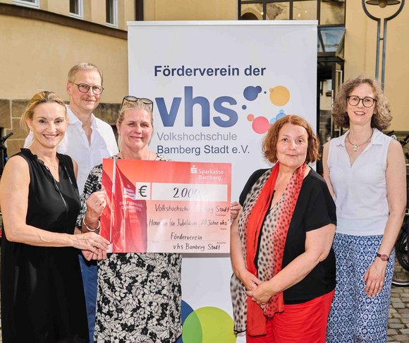 5 Personen halten einen Spendenscheck