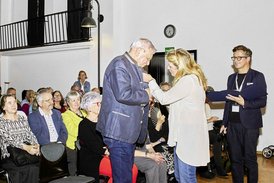 vhs-Leiterin Anna Scherbaum heftet Altbürgermeister Rudolf Grafberger die Goldene Ehrennadel ans Revers.