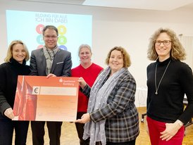 Zu sehen ist der Vorstand des Fördervereins. Sie halten den Spendenscheck der Sparkasse Bamberg über 2700 Euro für vier neue Notebooks in den Händen.