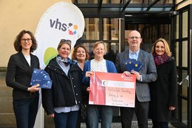 6 Personen halten einen Spendenscheck und vhs-Gutscheine für die KulturTafel in den Händen